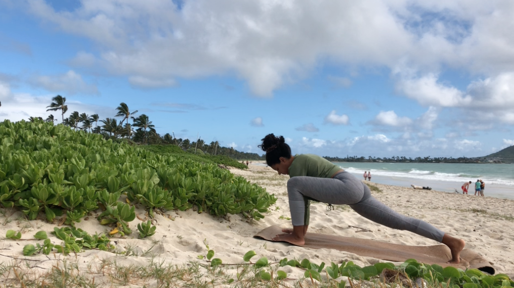 A black woman doing yoga as an online yoga class. 