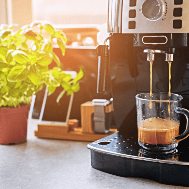 An espresso machine with a basil plant on kitchen counter