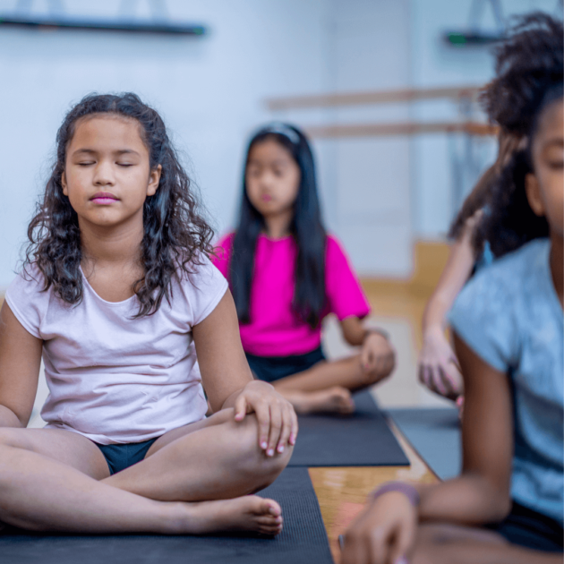 girls meditating on yoga mats as a self care practice