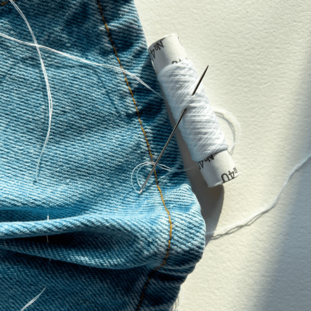 jeans and sewing needle to mend clothes at home for low waste living
