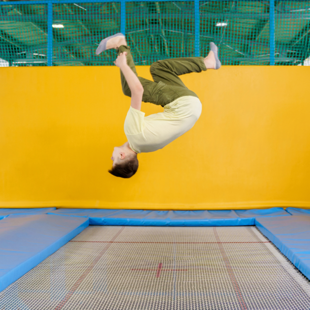 a man on a date doing a flip on a trampoline