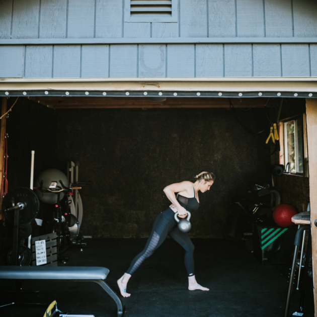 a woman doing a weightlifting session in her home garage gym