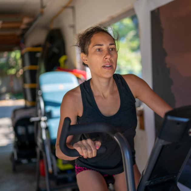 a woman on a stationary bike in her small garage