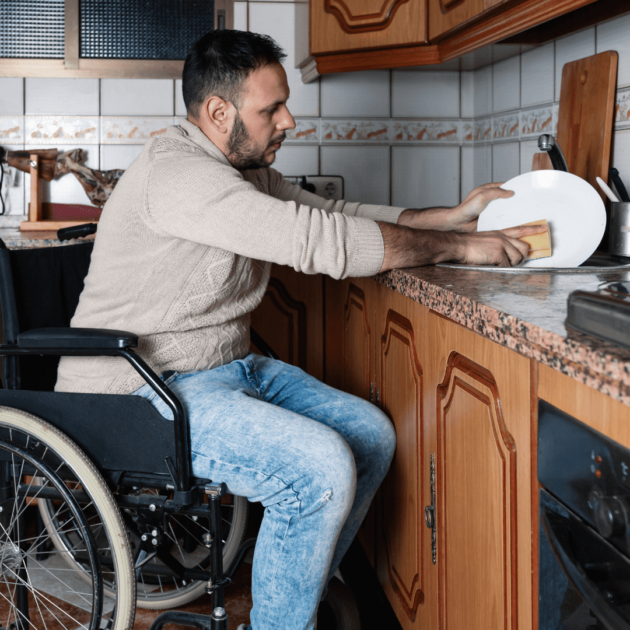 a person in a wheel chair washing dishes